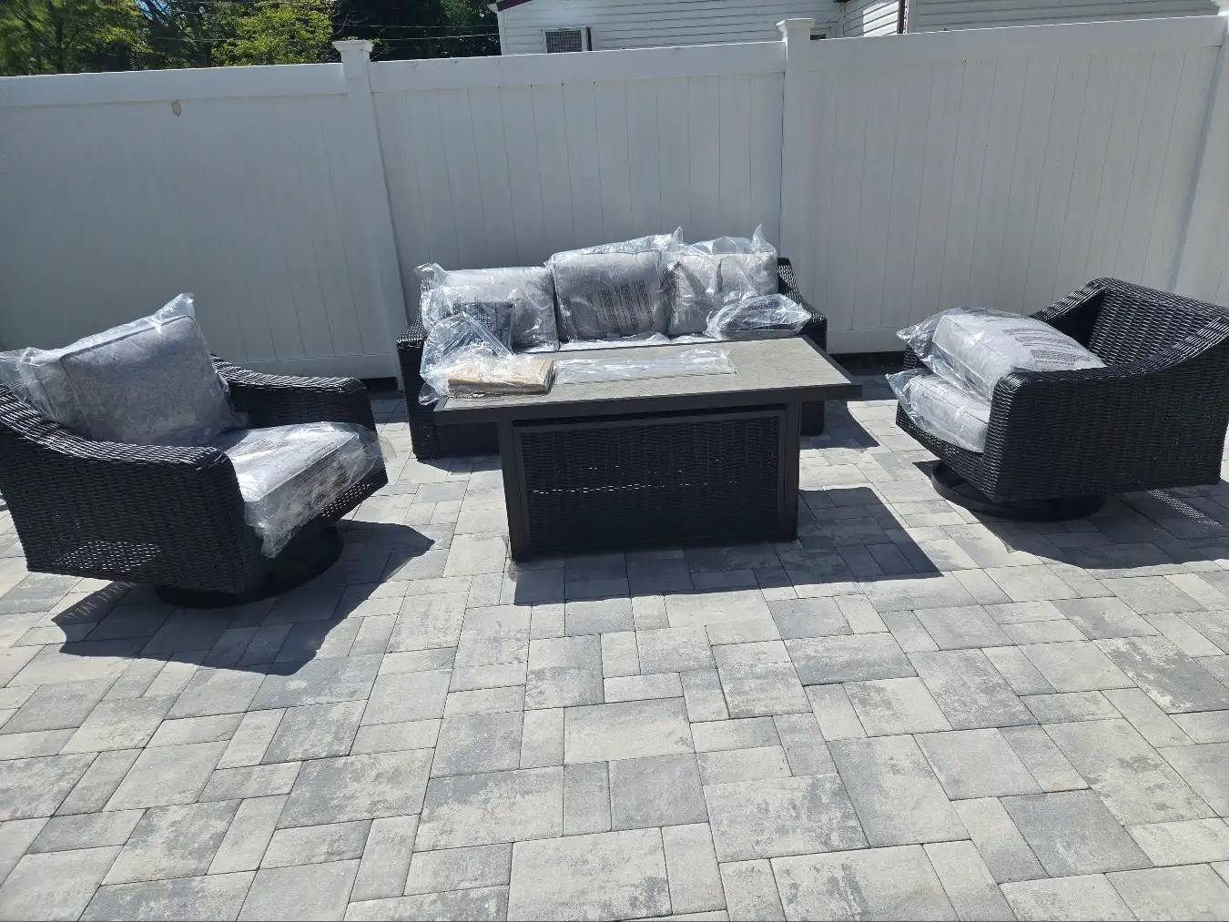 Three-cushion outdoor couch and two chairs surrounding a table on customer’s patio by RF Delivery
